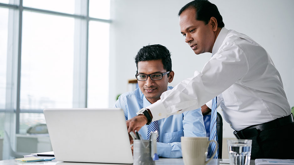 Indian business team discussing information on tablet computer