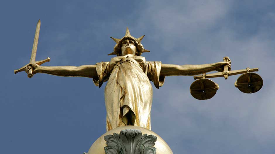 The Statue of Justice, depicted as a women with a sword in one hand and scale in her other, is seen on top of the London Central Criminal Court, the Old Bailey in London August 12, 2005.